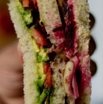vegetarian club sandwich in hand